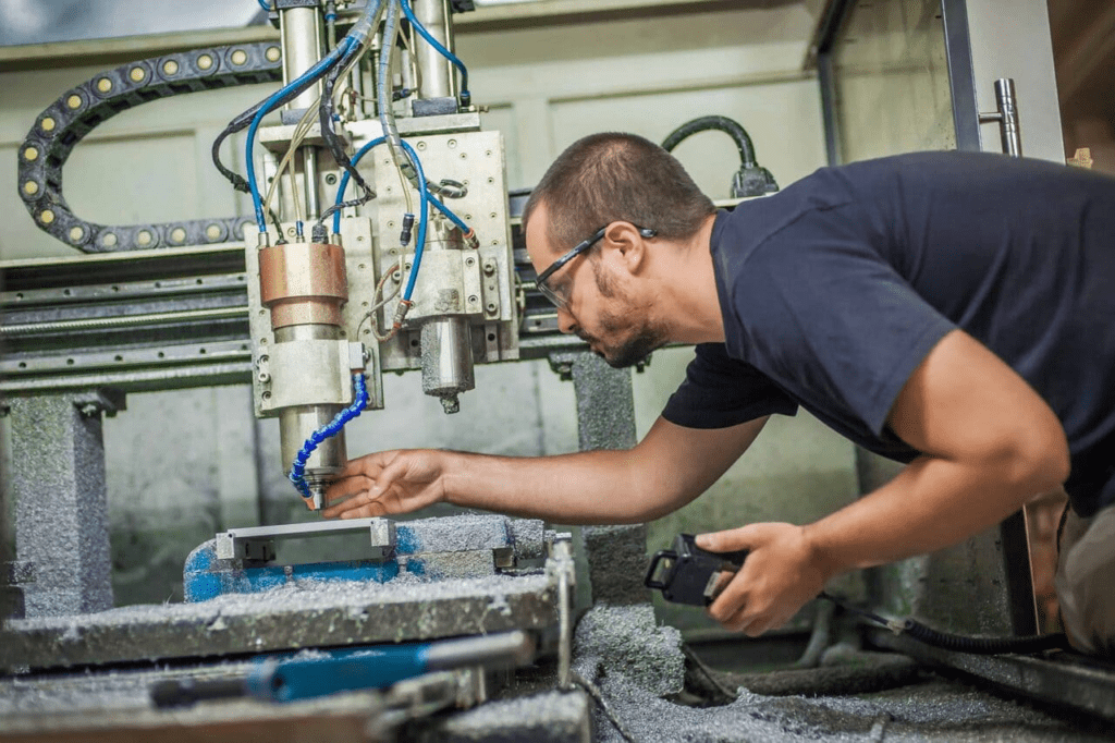 man adjusting CNC machine