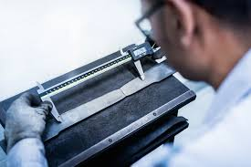 man taking metal measurements with a digital caliper