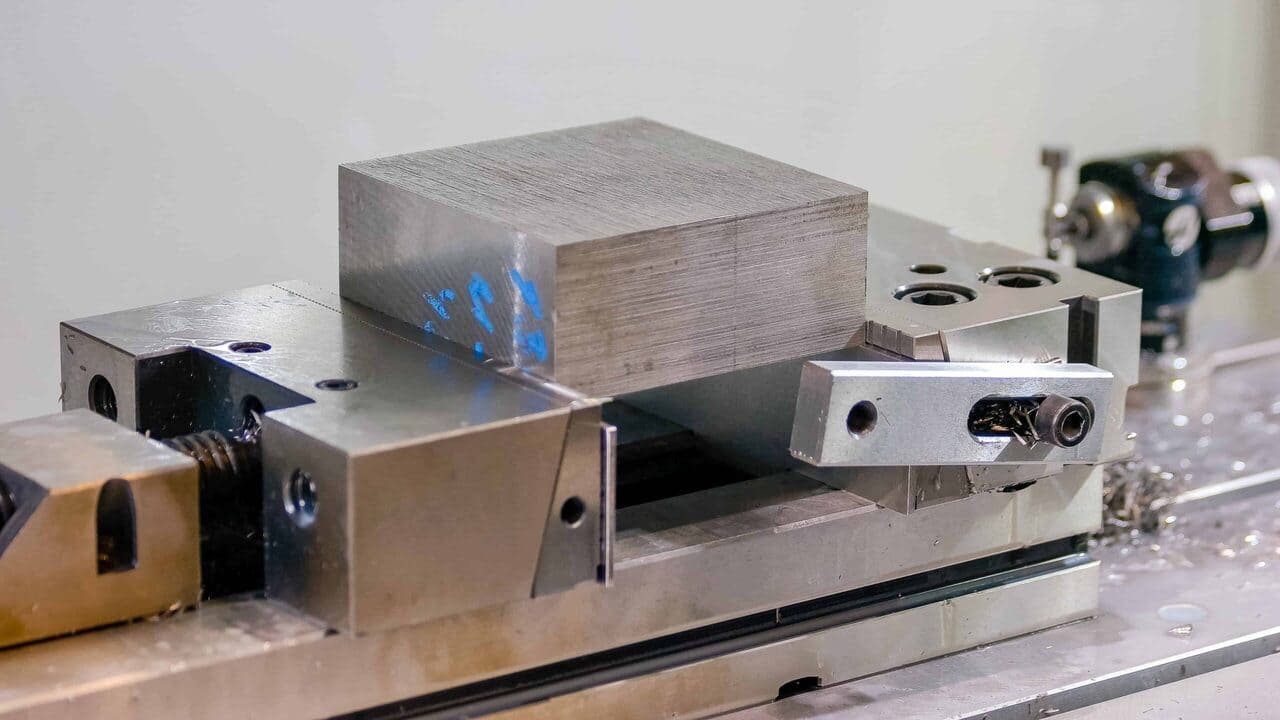 A-vice-with-aluminum-soft-jaws-fronted-with-tooling-plate-holds-metal-for-machining-scaled