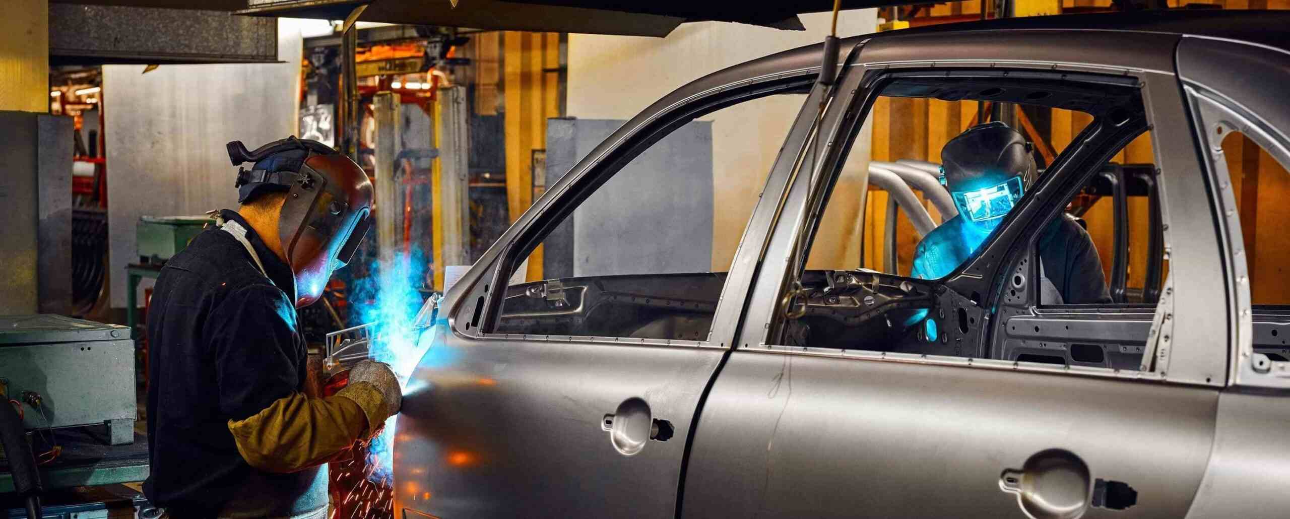 mechanical workers welding a vehicle