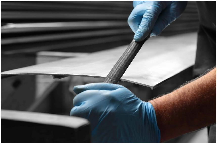 male hand wearing blue gloves bending a metal